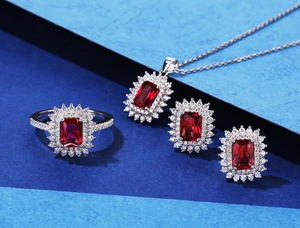 Detailed view of silver sunflower halo jewelry set with emerald-cut red gemstones