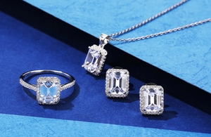 S925 Sterling Silber Schmuckset mit Smaragdschliff-Kristallen auf blauem Hintergrund