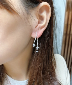 Detail of silver S925 long tassel drop earrings with sparkling rhinestones on model