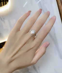 Detailed close-up of a 925 sterling silver ring with a large pearl and marquise zircon halo