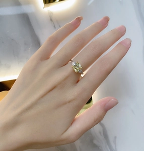 Detailed view of square yellow gemstone ring with triangle side stones on hand