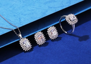 Detailed set of silver emerald-cut pendant, earrings and ring on a blue background