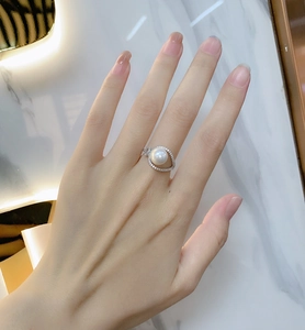 Macro shot of 925 silver ring featuring a round white pearl and teardrop zircon accents