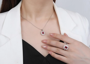 Detail of silver halo jewelry set with rectangular red gemstones and white diamonds