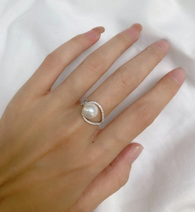 Close-up of elegant 925 silver ring featuring a white pearl and teardrop halo of zircons