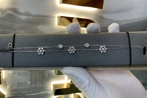 Makro-Detail des doppellagigen Schneeflocken-Armbands mit Zirkonia-Anhängern und feiner Kette