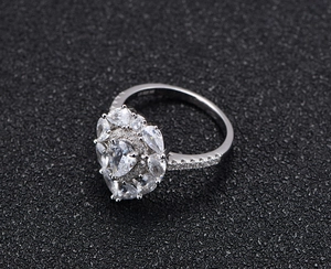 Macro shot of S925 silver ring featuring a pear-cut centerpiece with sunflower halo detail
