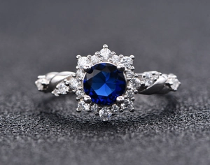 Macro detail of round blue halo ring with twisted band and intricate diamond accents