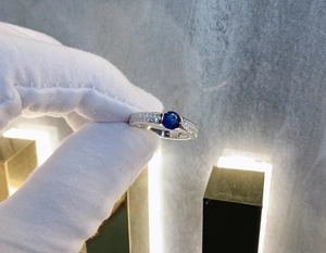 Detailed macro shot of a S925 silver ring featuring a round blue sapphire center stone