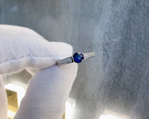 Macro shot of S925 sterling silver ring with a deep blue sapphire and micro-pave diamonds