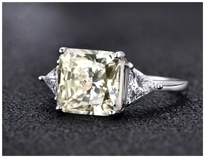 Macro shot of cushion-cut yellow gemstone ring with trillion side stones in 925 silver