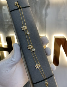 Detail eines vergoldeten zweilagigen Schneeflocken-Armbands mit Zirkonia-Blumen
