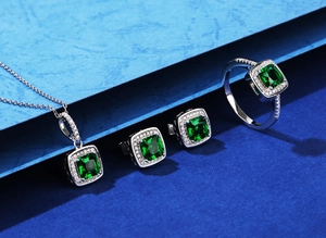 Macro shot of 925 silver jewelry set with square green emerald and white diamonds