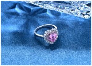 Close-up of pink heart-shaped crystal ring with double-layered halo pavé settings