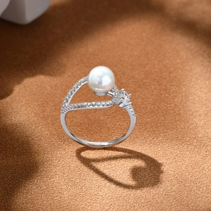 Elegant S925 silver pearl ring with heart-shaped shadow projection on brown surface