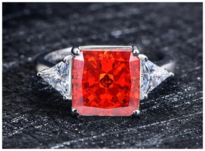Macro shot of a 925 silver ring with 10mm ice flower cut orange sapphire and side stones