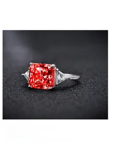 Macro view of square red gemstone ring with triangular diamonds and platinum-like finish