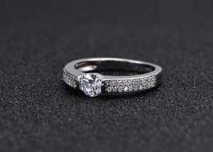 Detail showing classic S925 silver ring with round center stone and micro-pave setting
