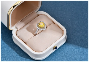 Close-up of heart-shaped yellow gemstone ring with halo diamonds in a premium gift box
