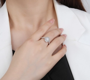 Detail of 925 sterling silver oval ring with halo design on a model's hand