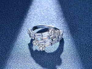 Macro detail of multi-layer silver ring featuring baguette-cut stones and floral accents