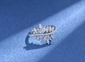 Macro d'une bague feuille en argent S925 avec diamants micro-pavé sur fond bleu foncé