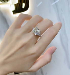 Detailed close-up of a square cut high carbon diamond ring on a hand with side stones