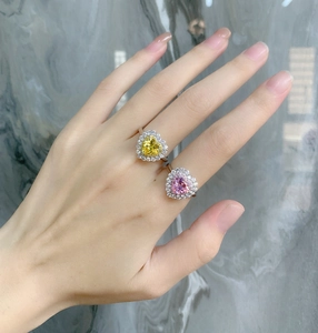 Close-up of heart-shaped pink and yellow high carbon diamond rings on model hand