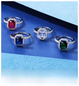 Dettaglio di quattro anelli con taglio smeraldo in rosso, blu, verde e bianco con halo