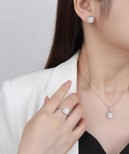 Detailed view of square halo jewelry set including necklace, ring and earrings on model