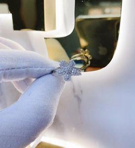 Close-up of a silver-toned five-petal flower ring featuring micro-pave diamond setting