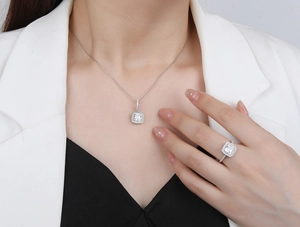 Detail of square-cut emerald simulant pendant and ring set on elegant model