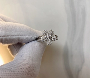 Macro detail of silver flower ring with micro-pave crystals and split open band