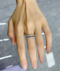 Macro shot of silver baguette cut eternity ring with sparkling stones on female hand