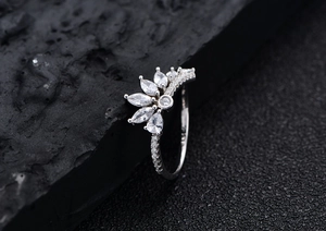 Vue macro d'une bague en argent S925 avec pierres marquises sur roche sombre