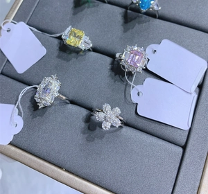 Macro shot of 925 silver rings with yellow and pink emerald-cut stones and flower motifs