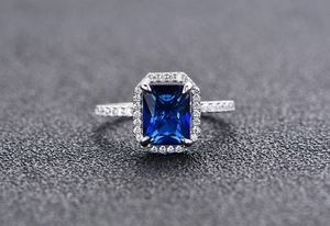 Vista macro dell'anello rettangolare in zaffiro blu con halo di diamanti lucidi