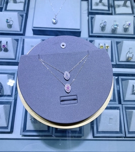 Détail de colliers en argent S925 en forme d'œil avec diamants roses et blancs