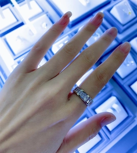 Detail of S925 silver eternity ring with baguette-cut zircon stones on a finger