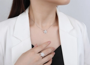 Close-up of sparkling micro-pave flower necklace and ring set on an elegant model
