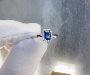 Macro detail of S925 silver ring featuring a blue rectangular gemstone and halo setting