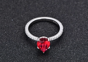 Macro shot of S925 silver ring featuring a pear-cut red sapphire in classic prong setting