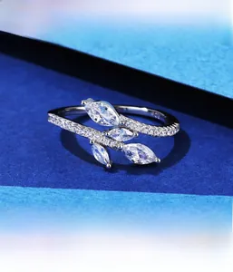 Macro detail of S925 sterling silver ring with marquise zircon leaves on blue background