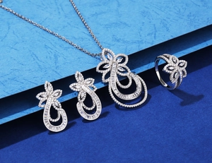 Detailed close-up of a 4-piece silver jewelry set featuring floral and teardrop motifs