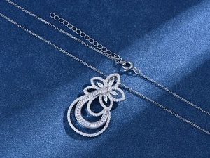 Macro shot of S925 sterling silver pendant with pavé cubic zirconia on blue background