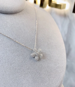 Détail du pendentif fleur en argent 925 avec pavé de cristaux sur support gris