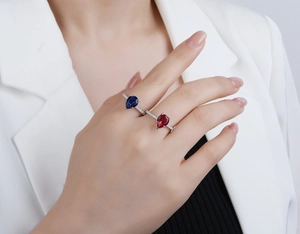 Macro shot of two pear-cut sapphire and ruby rings with pavé micro-inlay on silver band