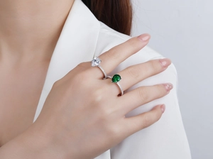 Close-up of pear-cut blue sapphire and white zircon rings on model finger