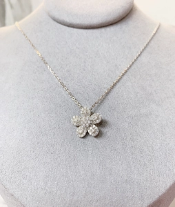 Détail du collier fleur avec micro-pavé de zircons sur un modèle de cou en velours gris