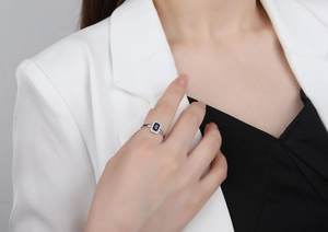 Close-up of S925 silver ring featuring a blue emerald-cut stone with a halo setting